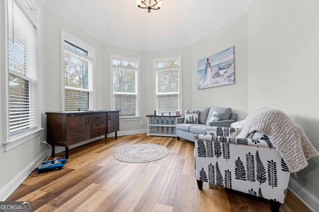 a living room with furniture and a wooden floor