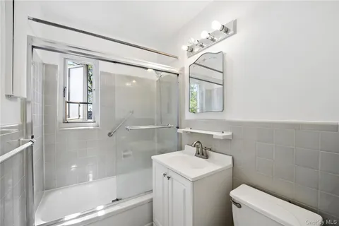 a bathroom with a bathtub shower sink vanity and toilet