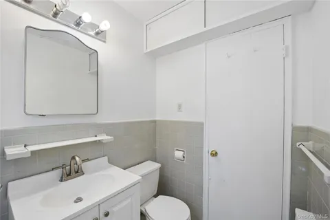 a bathroom with a toilet sink and mirror