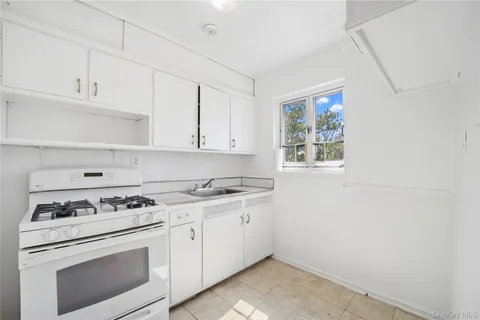a kitchen with cabinets appliances a sink and a window