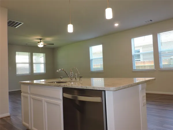 a kitchen with a sink cabinets and wooden floor