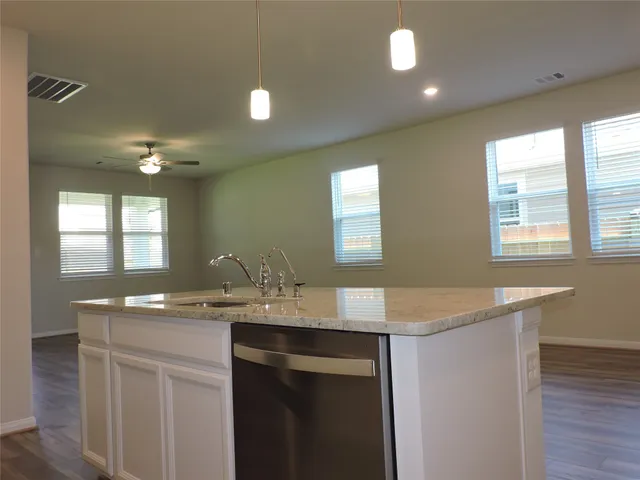a kitchen with a sink cabinets and wooden floor