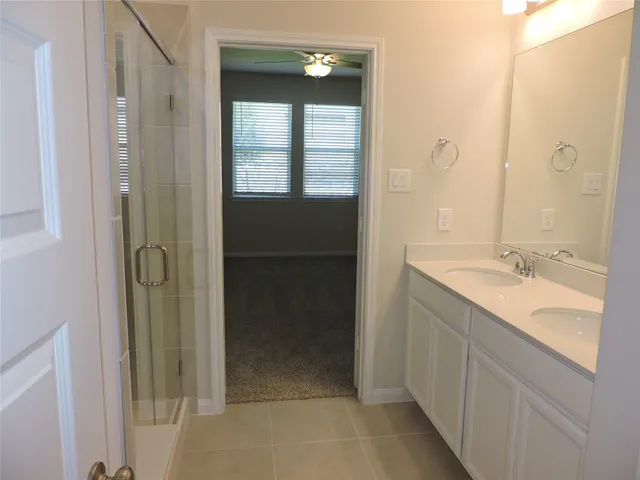 a bathroom with a double vanity sink a mirror and a shower