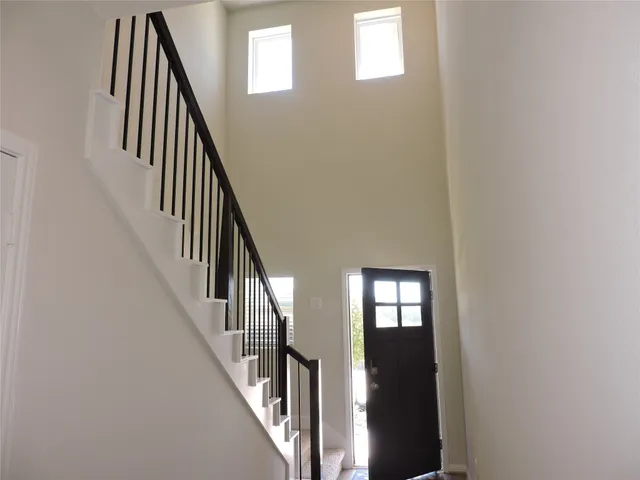 an entryway with wooden floor and stairs