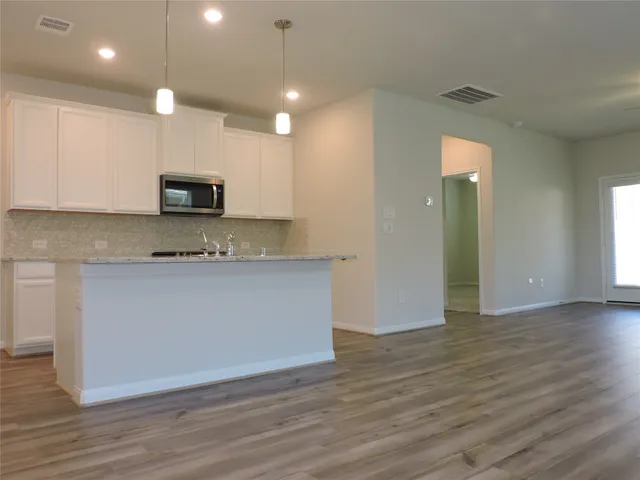 a view of kitchen with granite countertop window and a sink