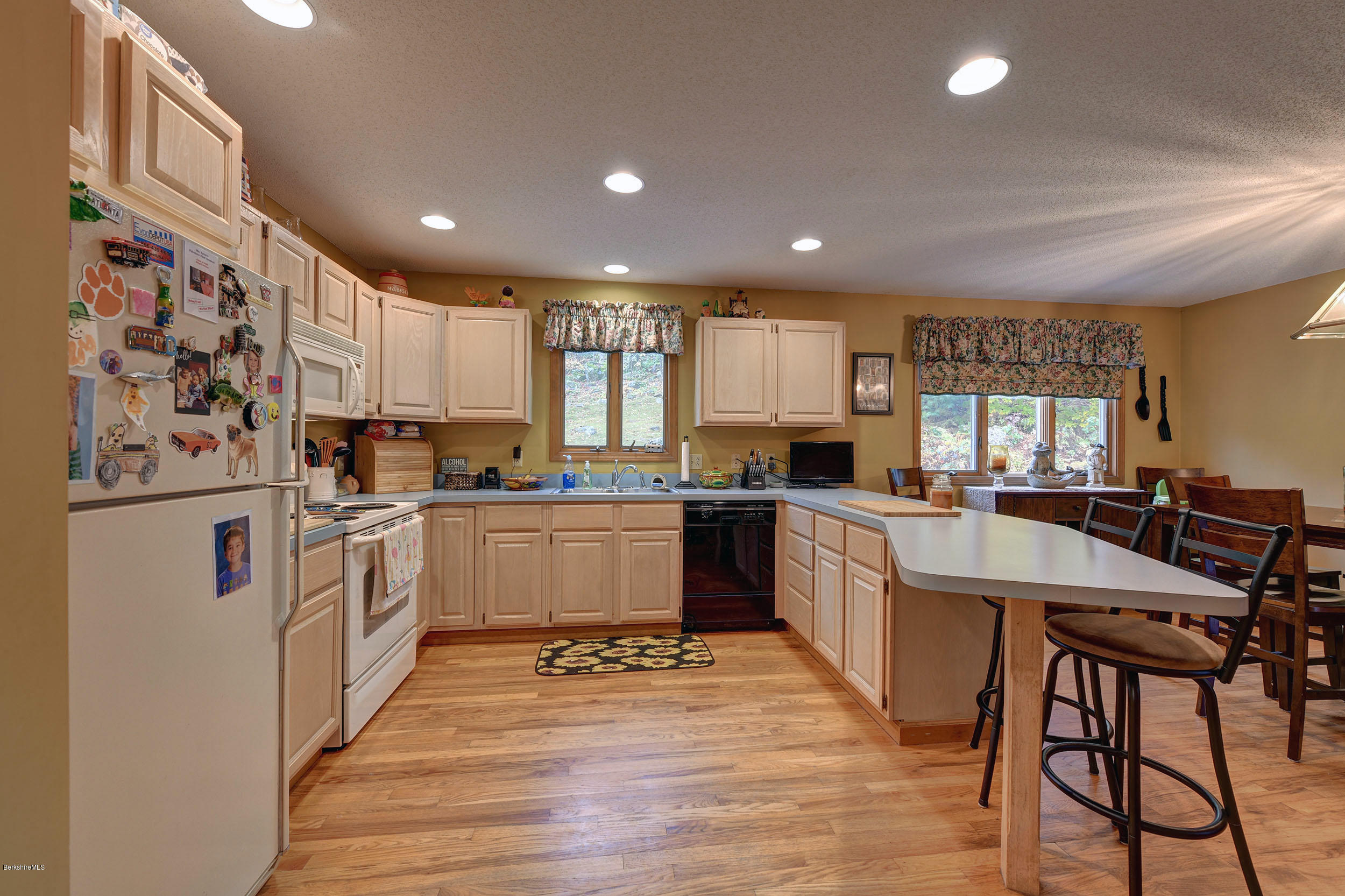 99 Jacobs Hollow Road Becket, MA 01223 - Photo 19 of 39 a large kitchen with stainless steel appliances lots of counter top space and wooden floor