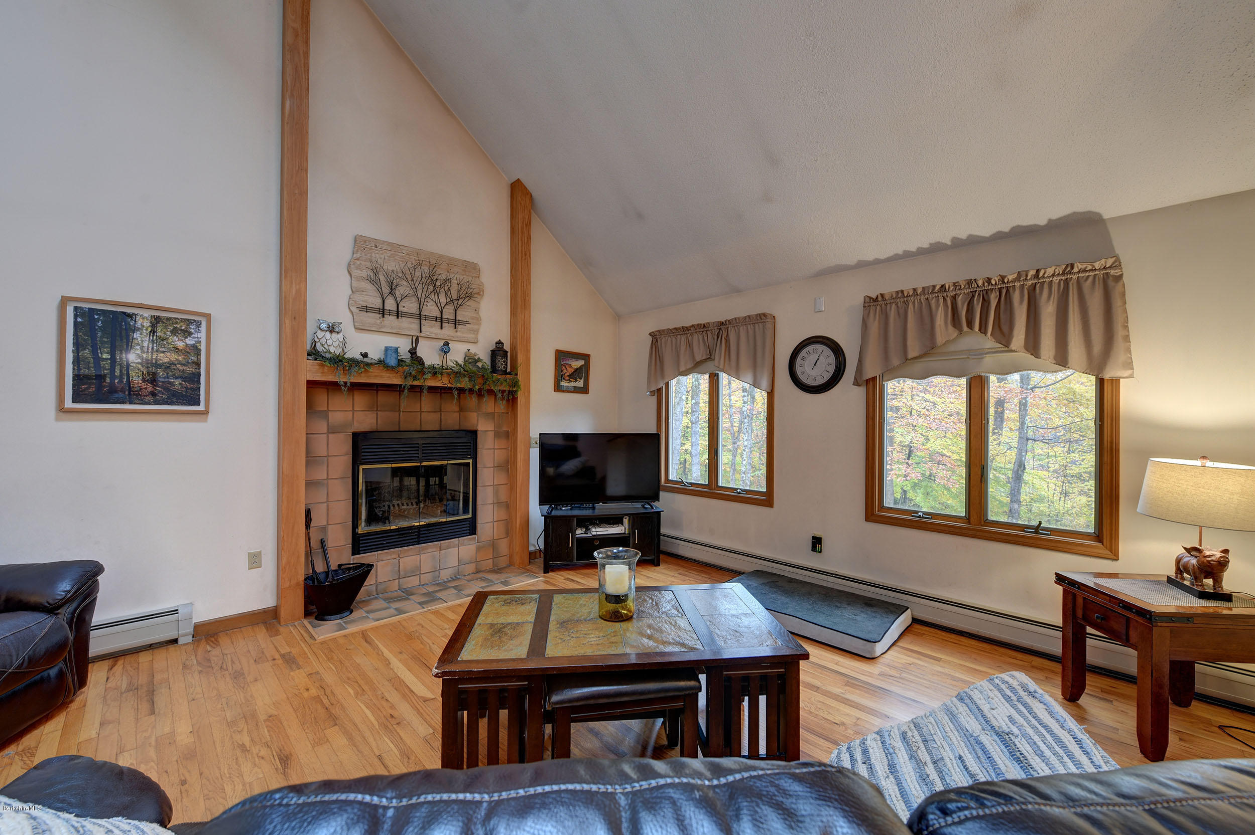 99 Jacobs Hollow Road Becket, MA 01223 - Photo 24 of 39 a living room with furniture a fireplace and a large window