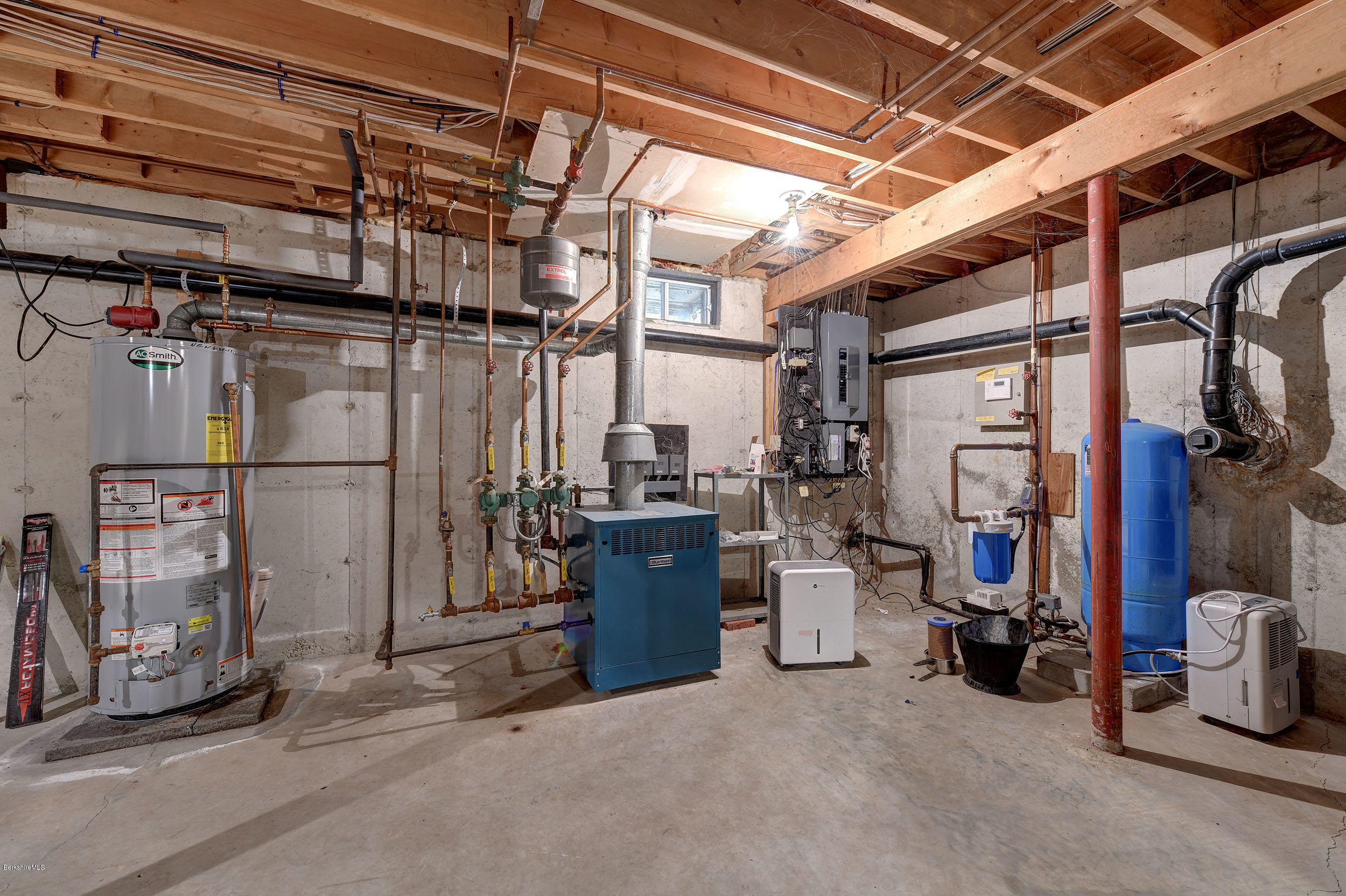 99 Jacobs Hollow Road Becket, MA 01223 - Photo 37 of 39 a view of a storage room with water heater and racks
