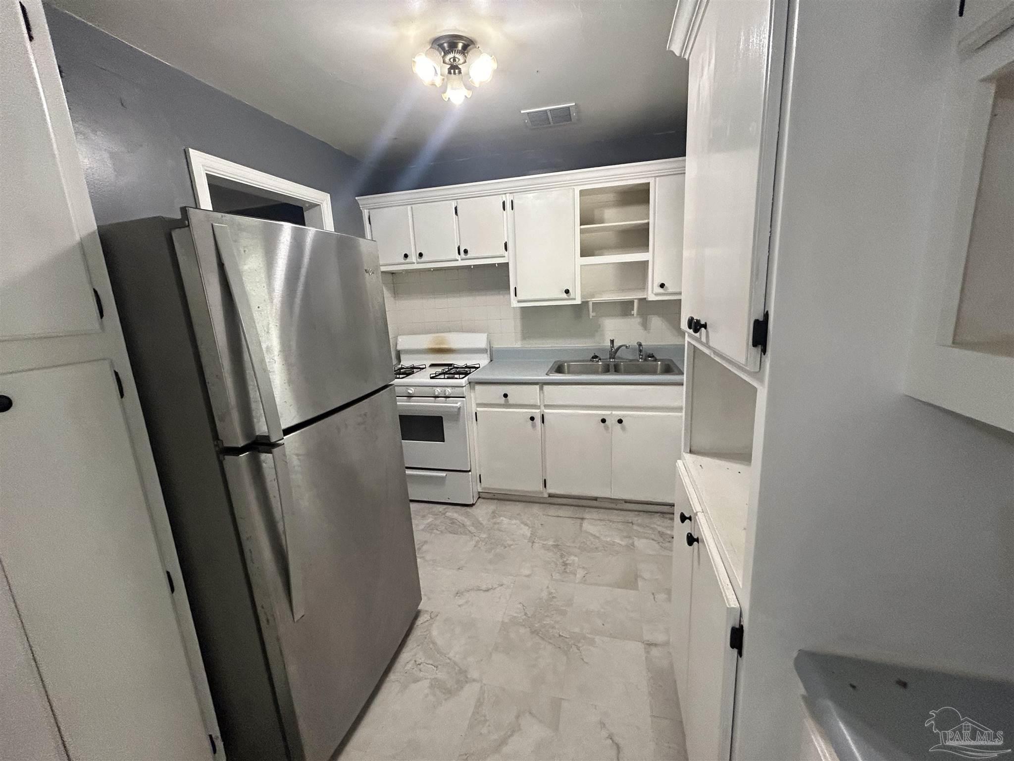 210 Milton Road Pensacola, FL 32507 - Photo 8 of 17 a kitchen with stainless steel appliances a refrigerator sink and cabinets