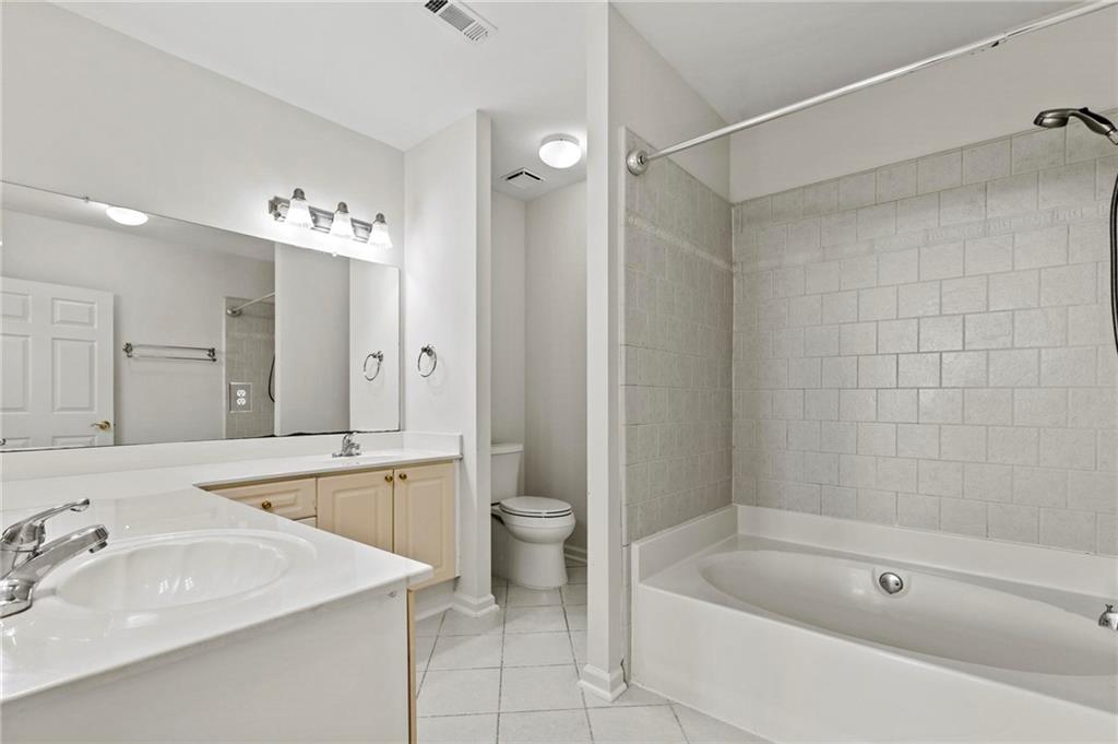 3334 Peachtree Road Northeast, Unit 1207 Atlanta, GA 30326 - Photo 18 of 31 a bathroom with a tub a sink and a large mirror