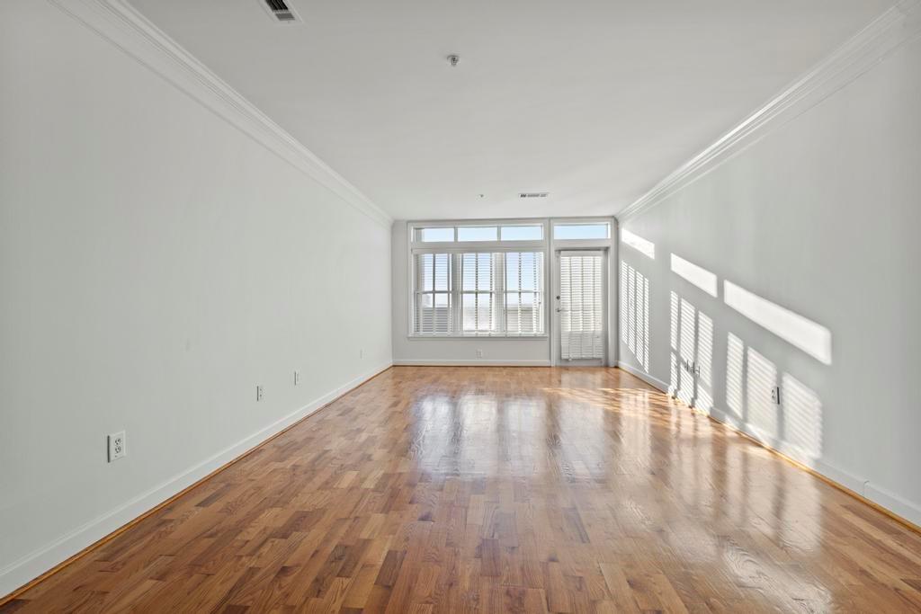 3334 Peachtree Road Northeast, Unit 1207 Atlanta, GA 30326 - Photo 4 of 31 a view of an empty room with wooden floor and fan