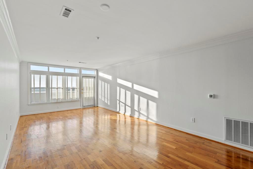 3334 Peachtree Road Northeast, Unit 1207 Atlanta, GA 30326 - Photo 5 of 31 a view of an empty room with wooden floor and a window
