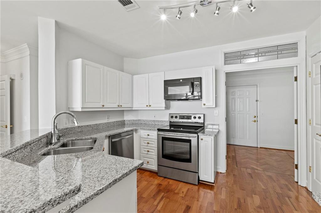 3334 Peachtree Road Northeast, Unit 1207 Atlanta, GA 30326 - Photo 7 of 31 a kitchen with stainless steel appliances granite countertop a sink stove and refrigerator