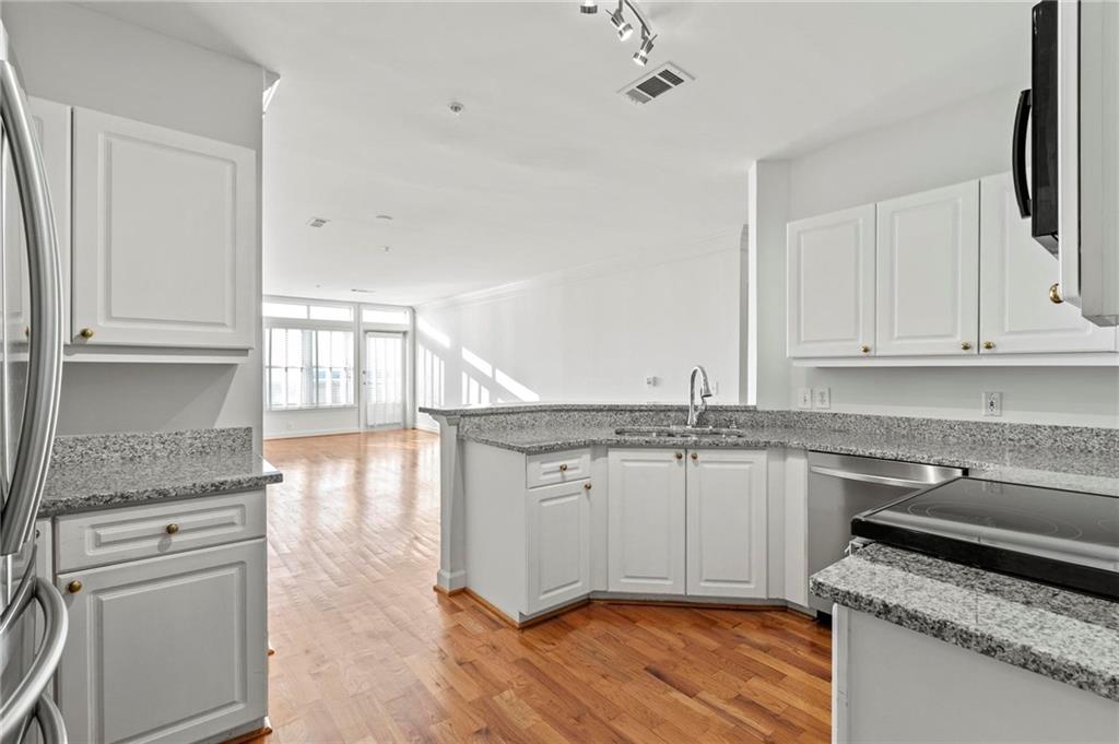 3334 Peachtree Road Northeast, Unit 1207 Atlanta, GA 30326 - Photo 8 of 31 a kitchen with granite countertop a sink cabinets stainless steel appliances and a counter space
