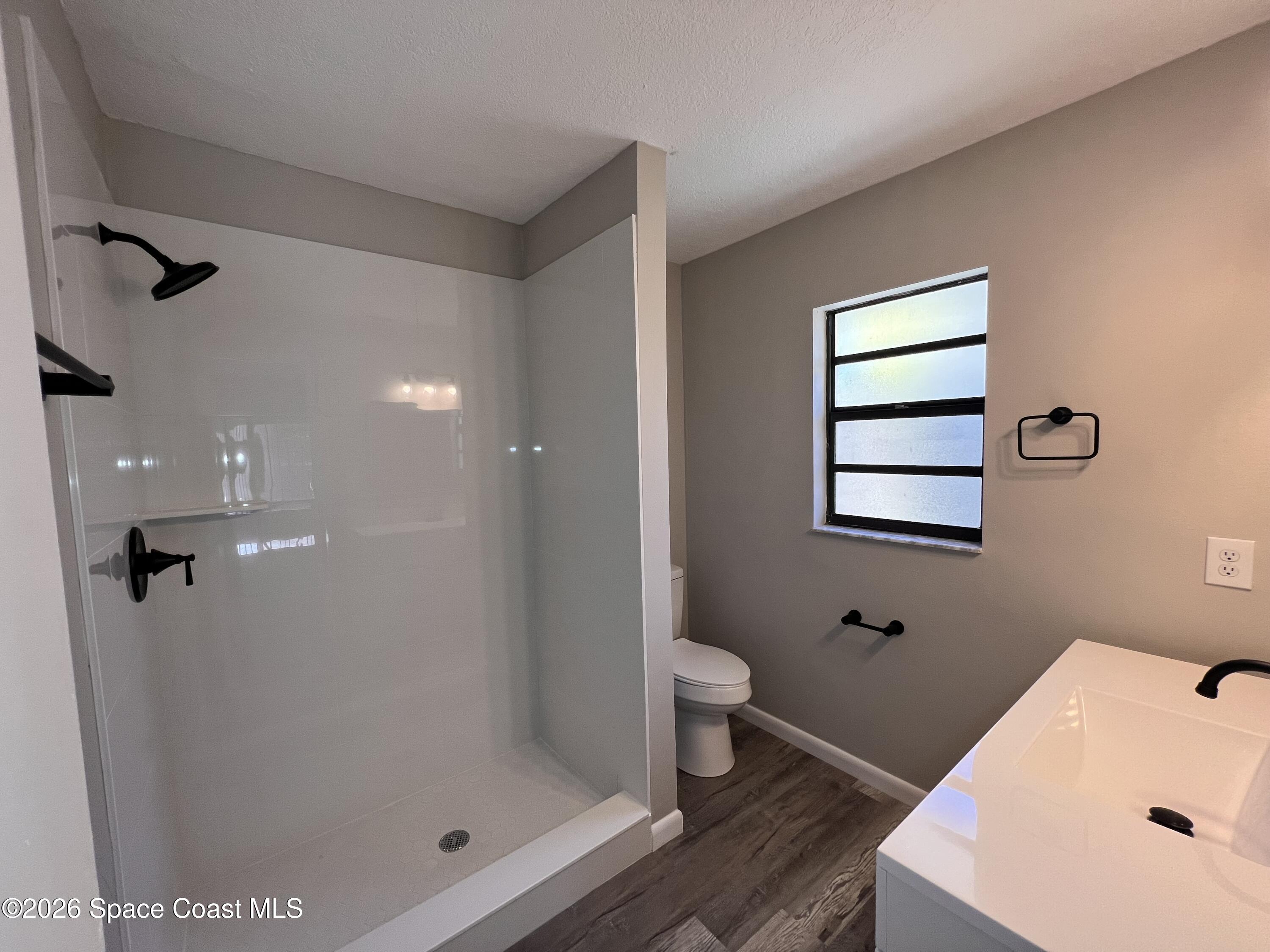 1456 Reed Street Northwest Palm Bay, FL 32907 - Photo 11 of 19 a bathroom with a sink a toilet and shower