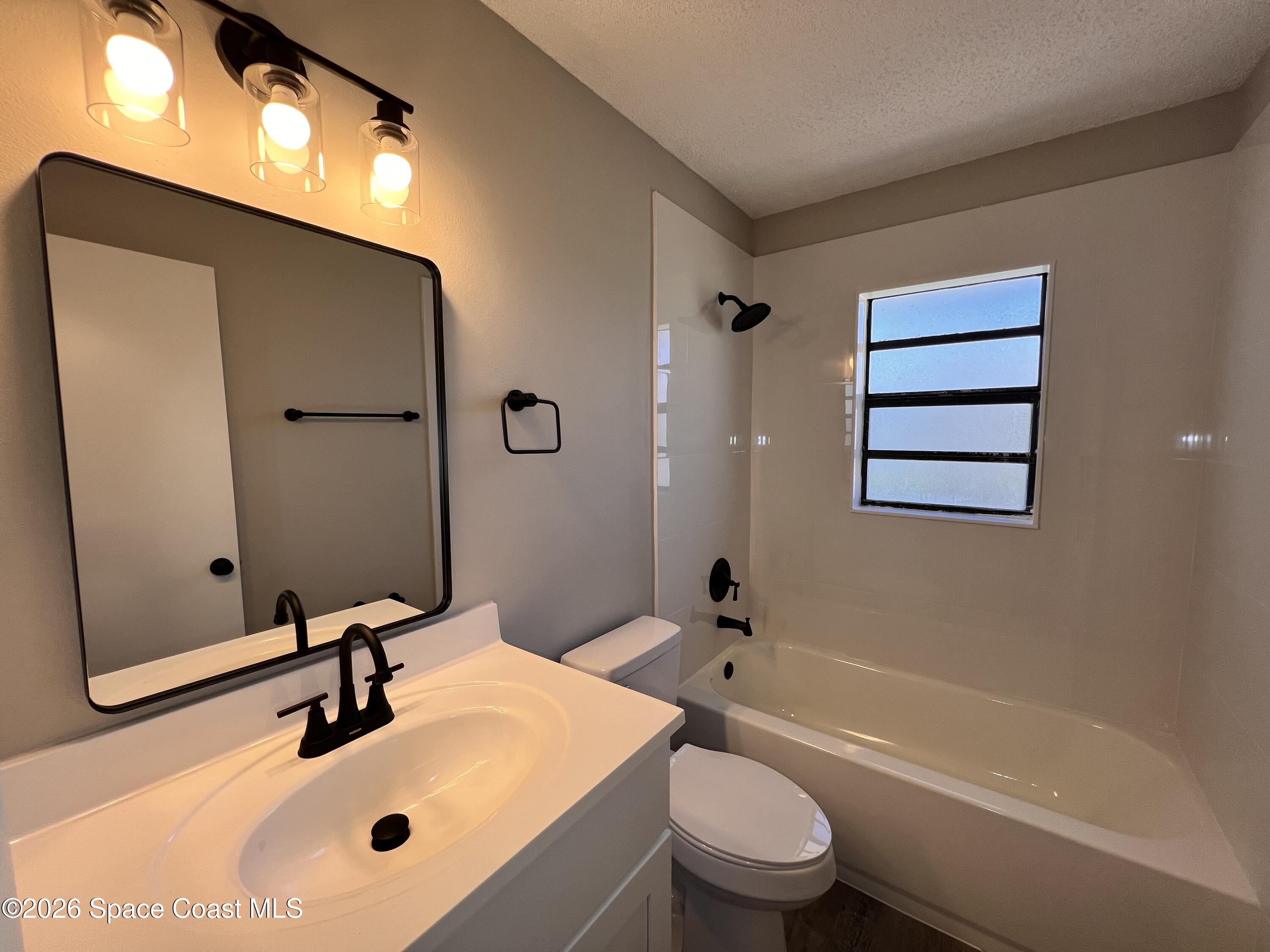 1456 Reed Street Northwest Palm Bay, FL 32907 - Photo 14 of 19 a bathroom with a sink a toilet and a bathtub