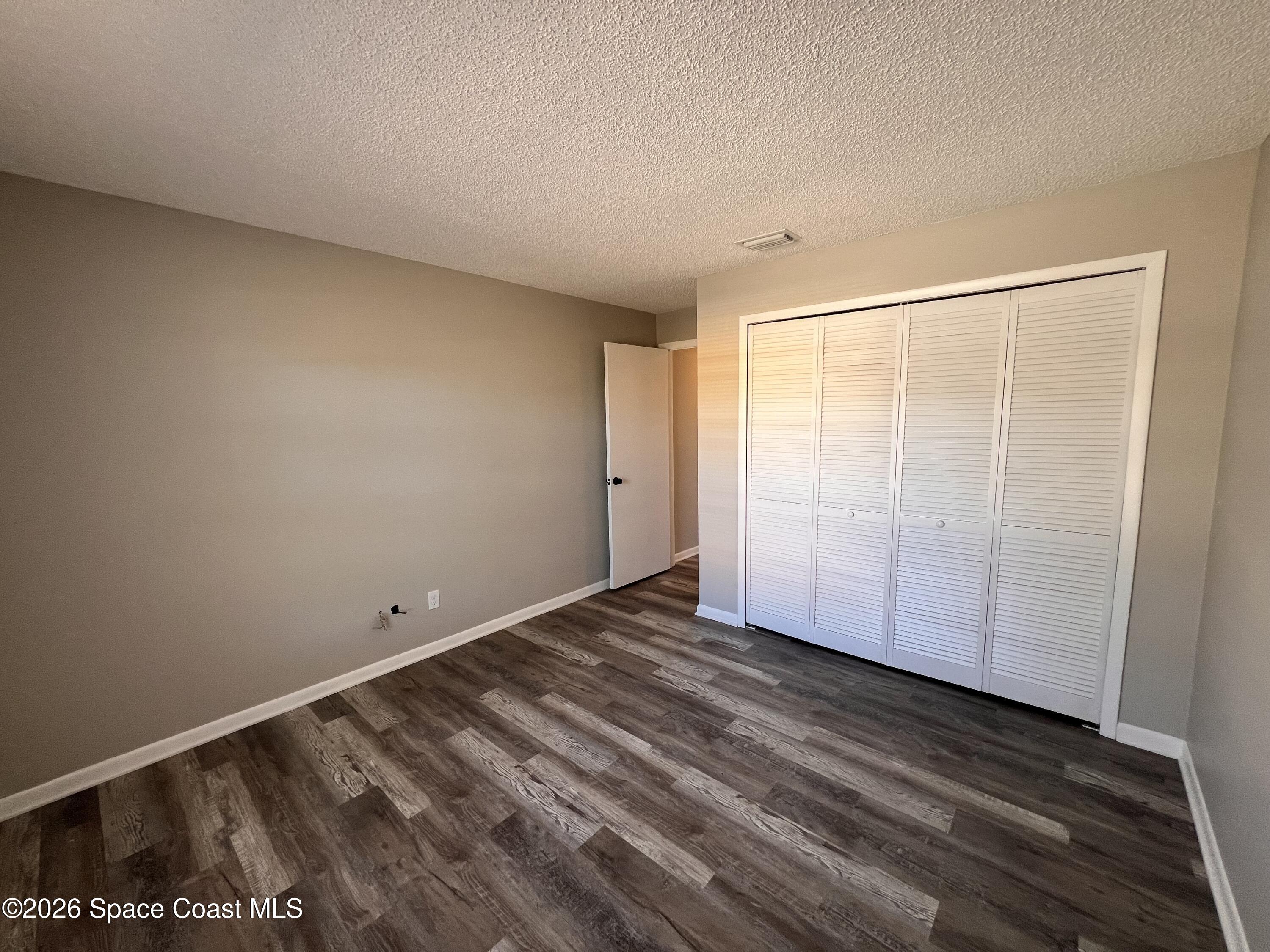 1456 Reed Street Northwest Palm Bay, FL 32907 - Photo 15 of 19 a view of a room with wooden floor and white walls