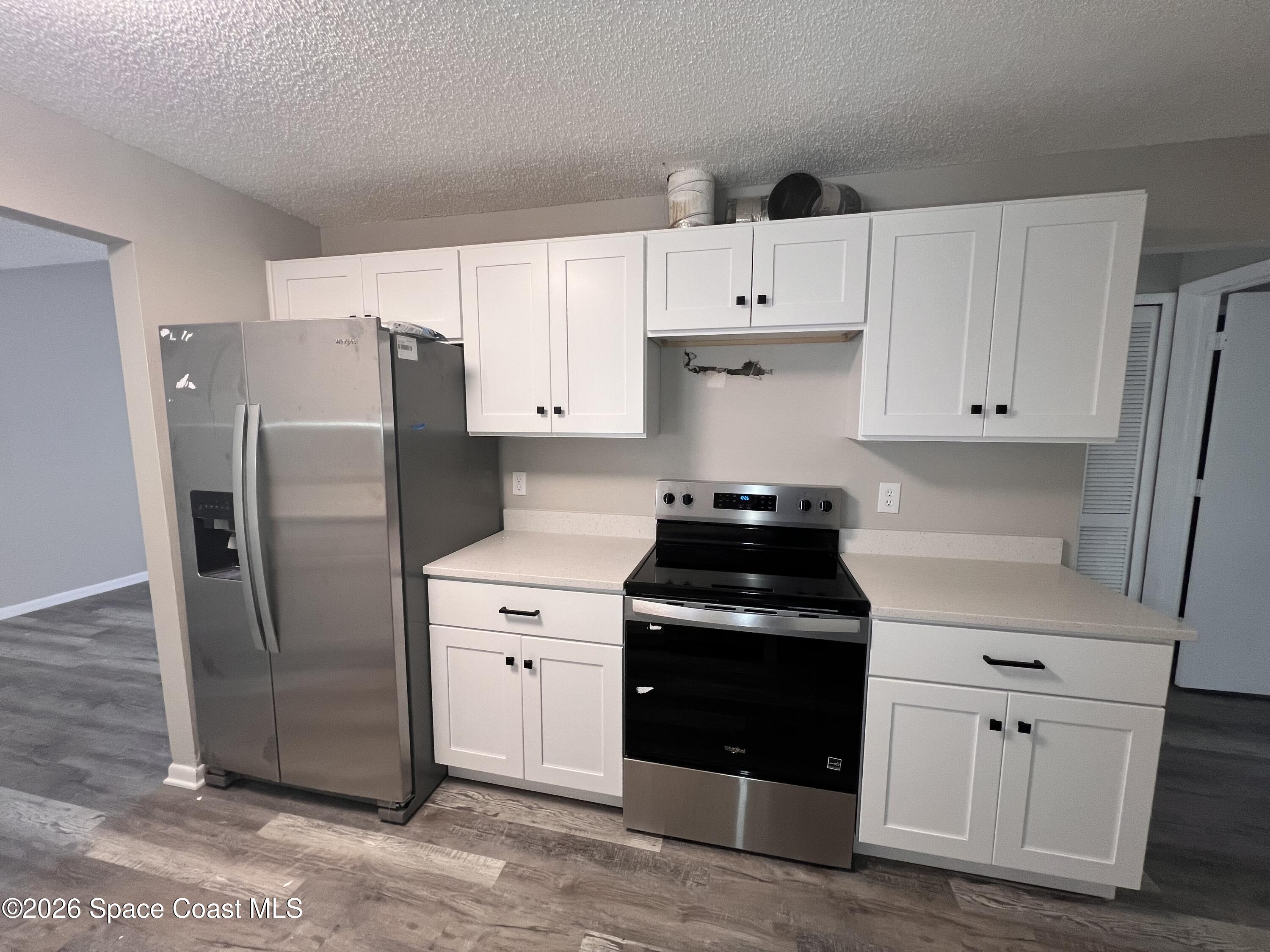 1456 Reed Street Northwest Palm Bay, FL 32907 - Photo 5 of 19 a kitchen with a refrigerator sink and cabinets