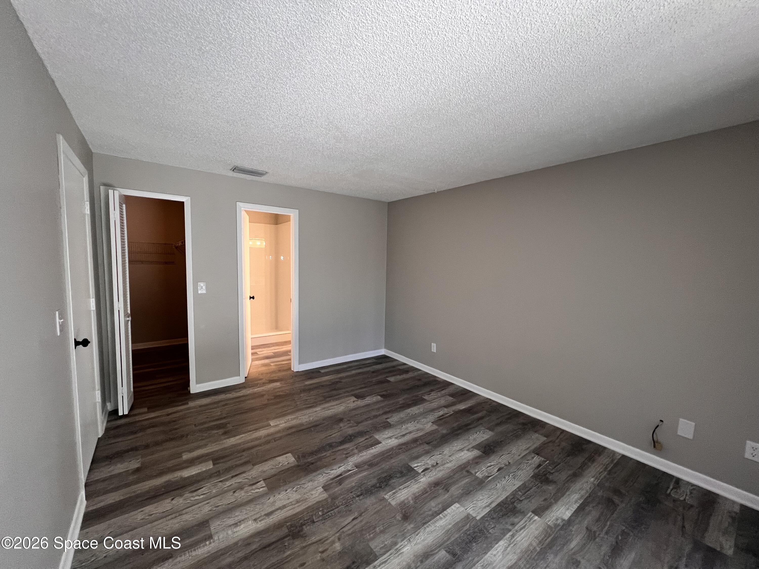 1456 Reed Street Northwest Palm Bay, FL 32907 - Photo 9 of 19 a view of an empty room with wooden floor and closet