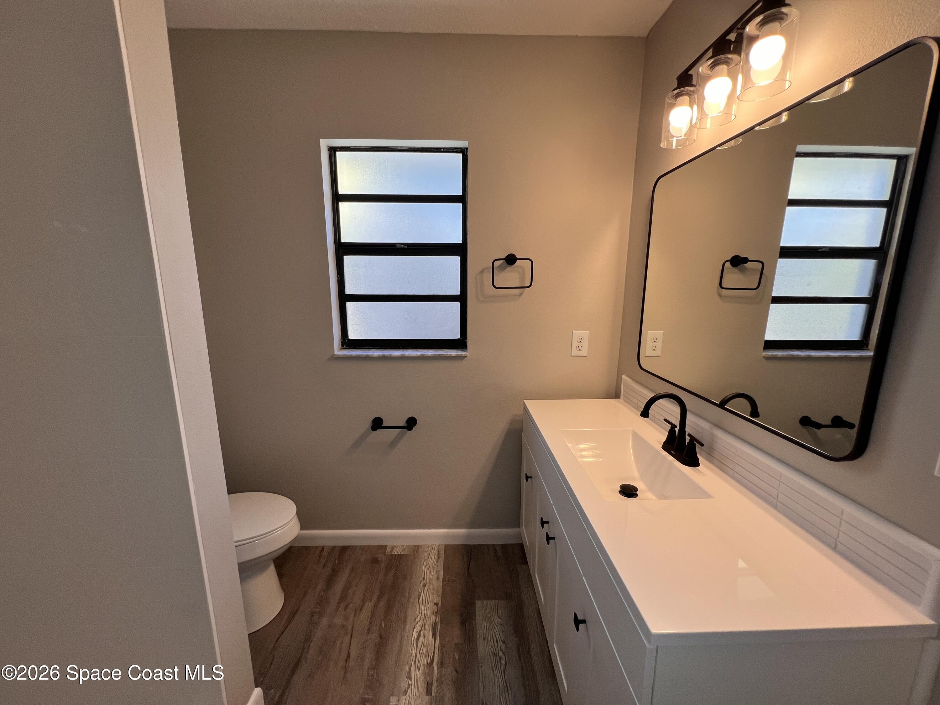 1456 Reed Street Northwest Palm Bay, FL 32907 - Photo 10 of 19 a bathroom with a sink a toilet and mirror