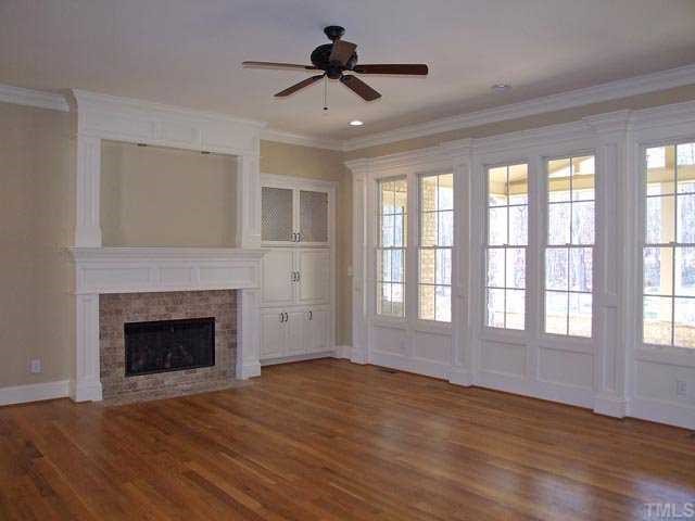5136 Terra Cotta Drive Raleigh, NC 27613 - Photo 3 of 12 a view of an empty room with wooden floor fireplace and a window