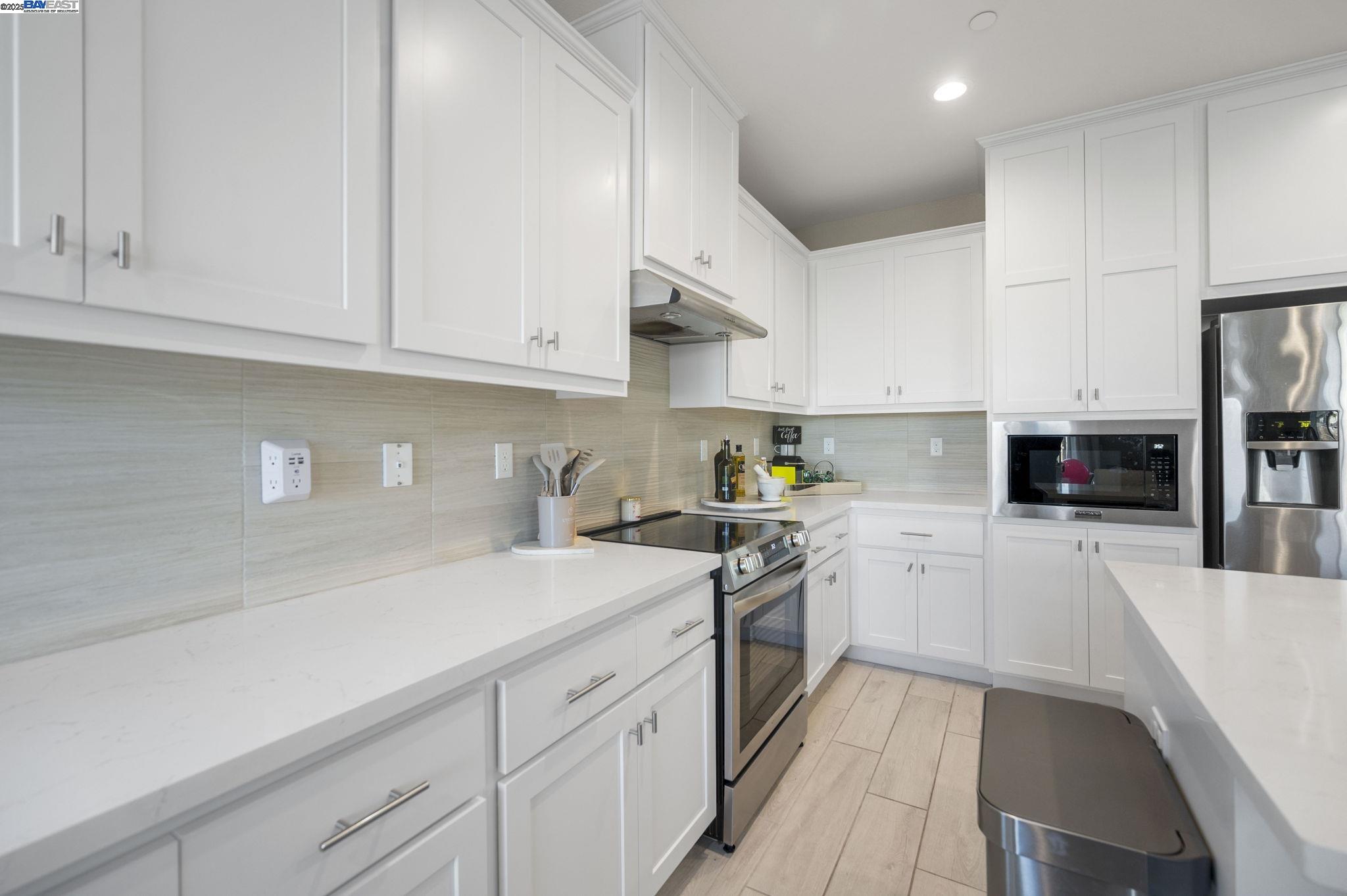 1605 Radiance Lane Modesto, CA 95356 - Photo 11 of 35 a kitchen with stainless steel appliances granite countertop a refrigerator sink and white cabinets