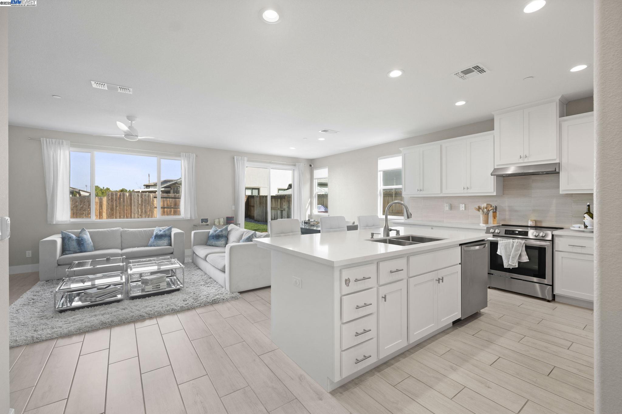 1605 Radiance Lane Modesto, CA 95356 - Photo 2 of 35 a large white kitchen with stainless steel appliances granite countertop a stove and a sink