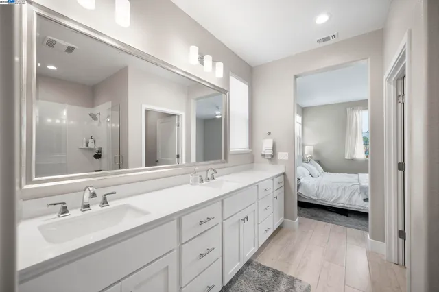 a en suite bathroom with double sink and a large mirror