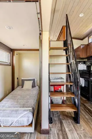 a bedroom with a bed and wooden floor