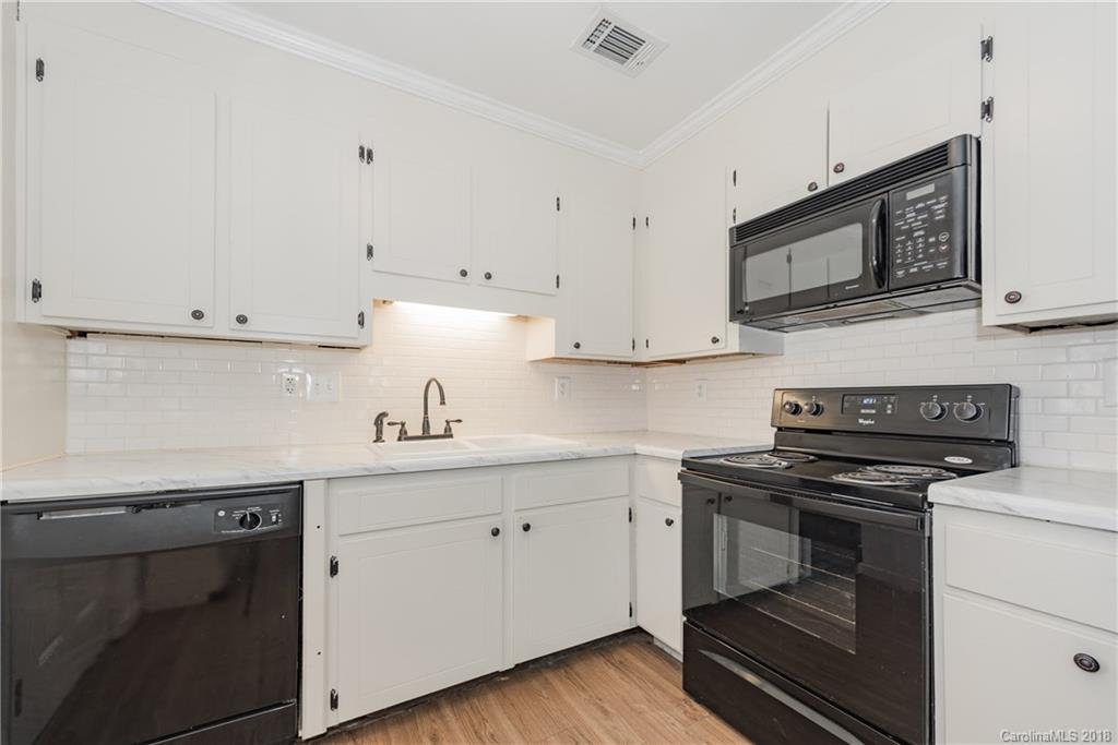 8002 Wynnview Road Indian Trail, NC 28079 - Photo 11 of 24 a kitchen with granite countertop white cabinets and stainless steel appliances