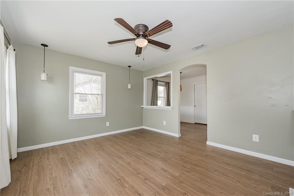 8002 Wynnview Road Indian Trail, NC 28079 - Photo 3 of 24 an empty room with wooden floor fan and windows