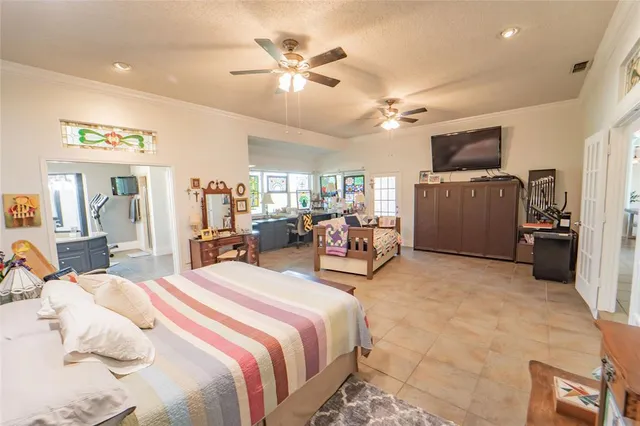 a spacious bedroom with a bed a couch and a flat screen tv