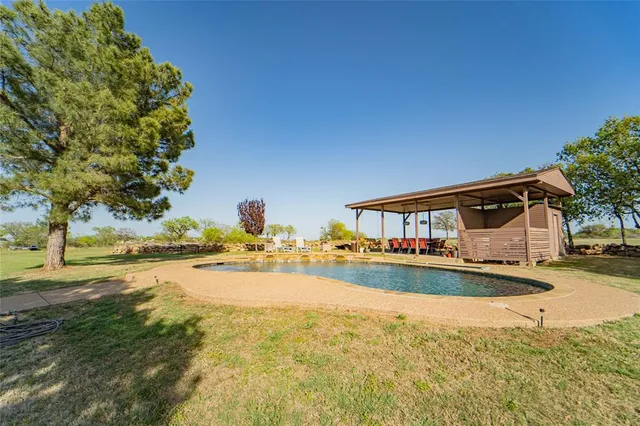 a front view of a house with swimming pool having outdoor seating