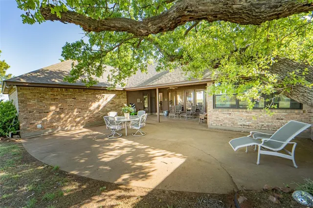 a backyard of a house with table and chairs