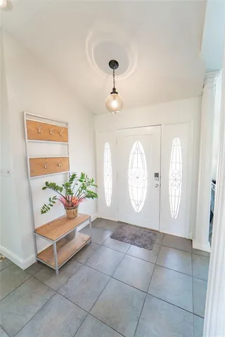 a living room with couches and a potted plant