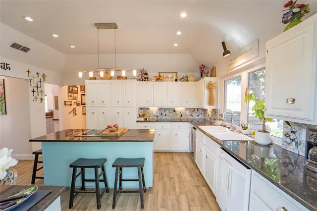 a large kitchen with lots of counter space and wooden floor