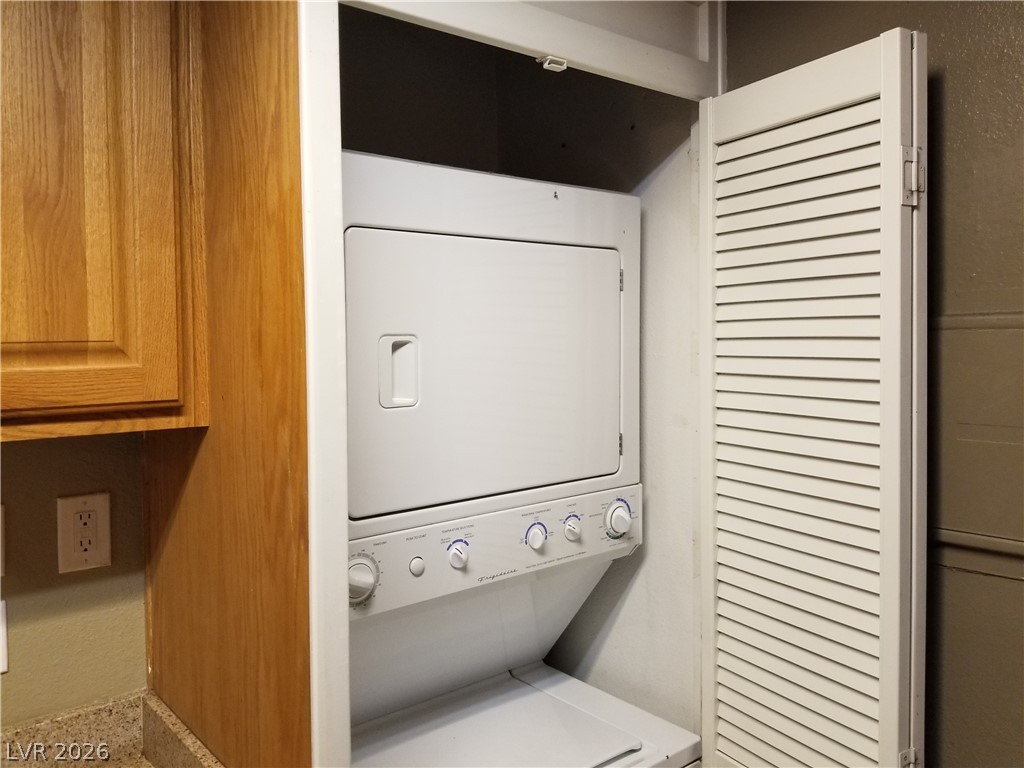 1515 East Reno Avenue, Unit A103 Las Vegas, NV 89119 - Photo 13 of 16 This compact laundry area features a stacked washer and dryer unit, maximizing utility in a streamlined space.