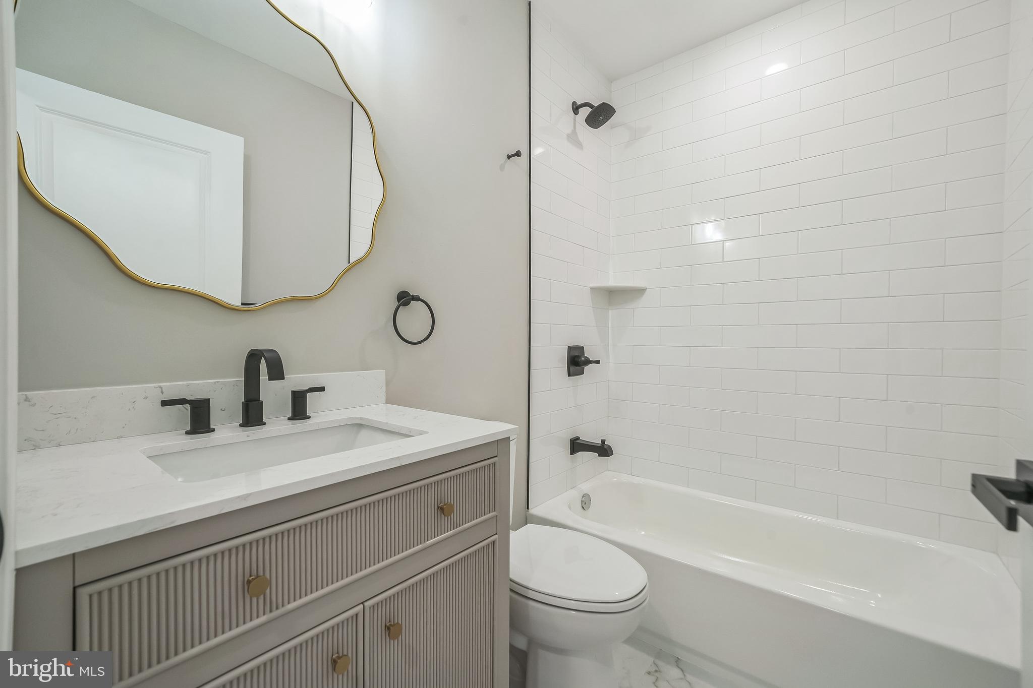 1702 South 22nd Street, Unit 3 Philadelphia, PA 19145 - Photo 11 of 22 a bathroom with a sink a toilet and a mirror