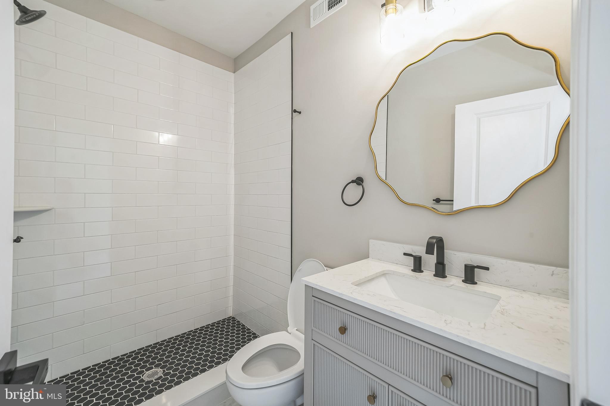 1702 South 22nd Street, Unit 3 Philadelphia, PA 19145 - Photo 12 of 22 a bathroom with a sink a toilet and a mirror