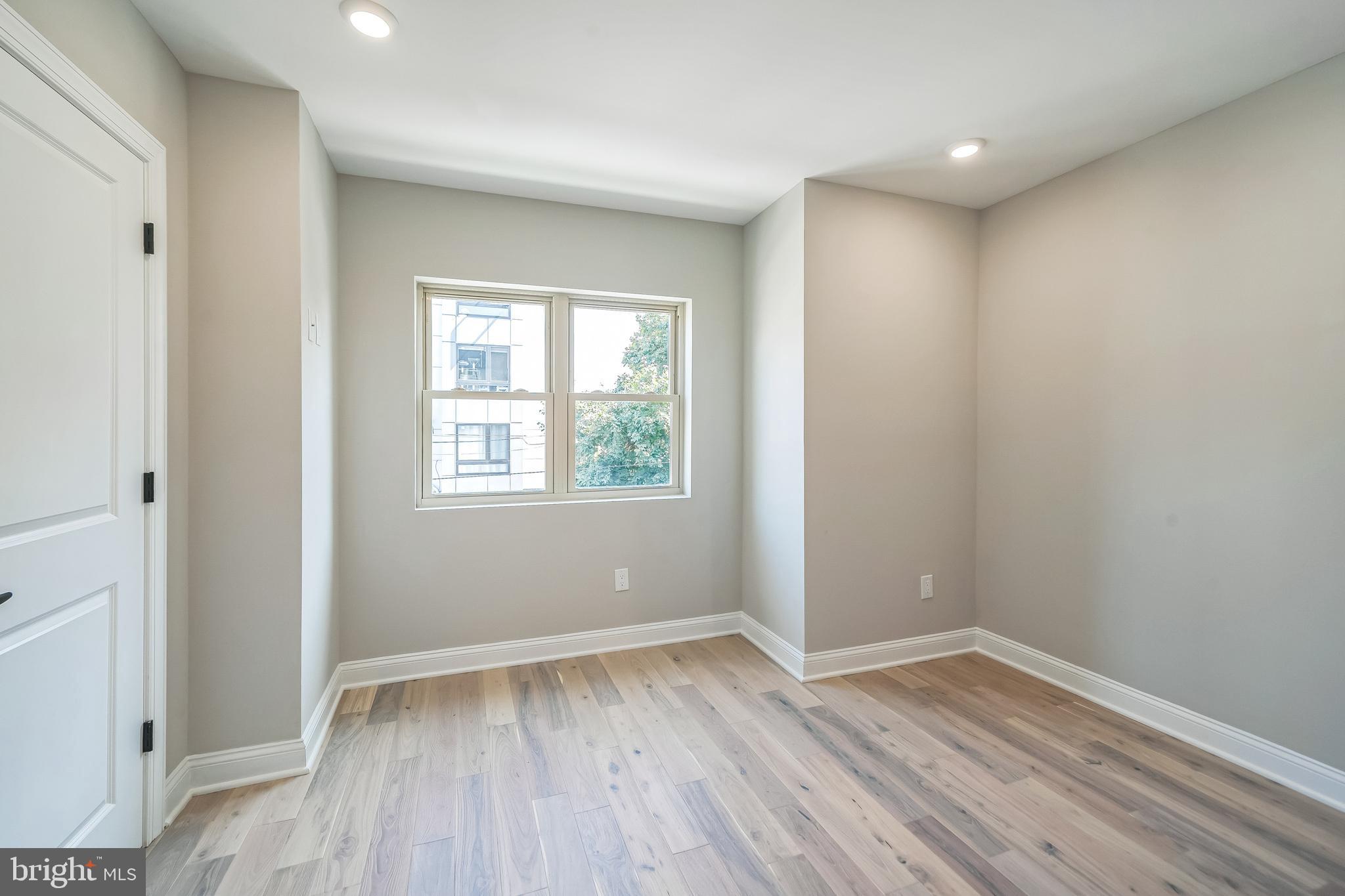 1702 South 22nd Street, Unit 3 Philadelphia, PA 19145 - Photo 18 of 22 an empty room with wooden floor and windows