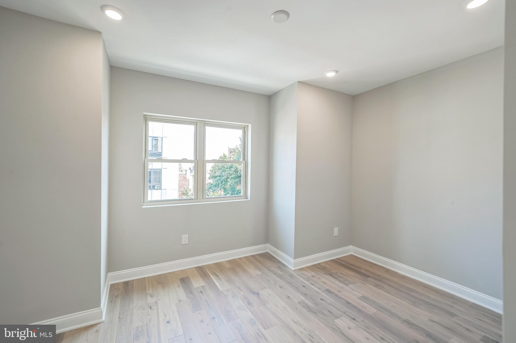 1702 South 22nd Street, Unit 3 Philadelphia, PA 19145 - Photo 19 of 22 an empty room with wooden floor and window