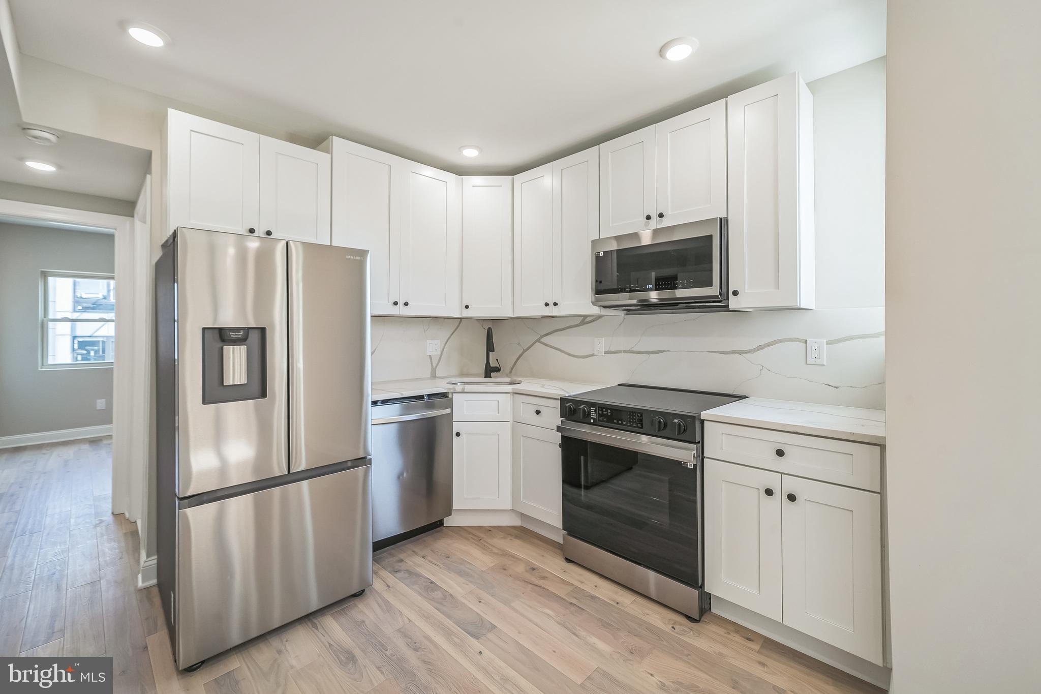 1702 South 22nd Street, Unit 3 Philadelphia, PA 19145 - Photo 6 of 22 a kitchen with stainless steel appliances white cabinets and a refrigerator
