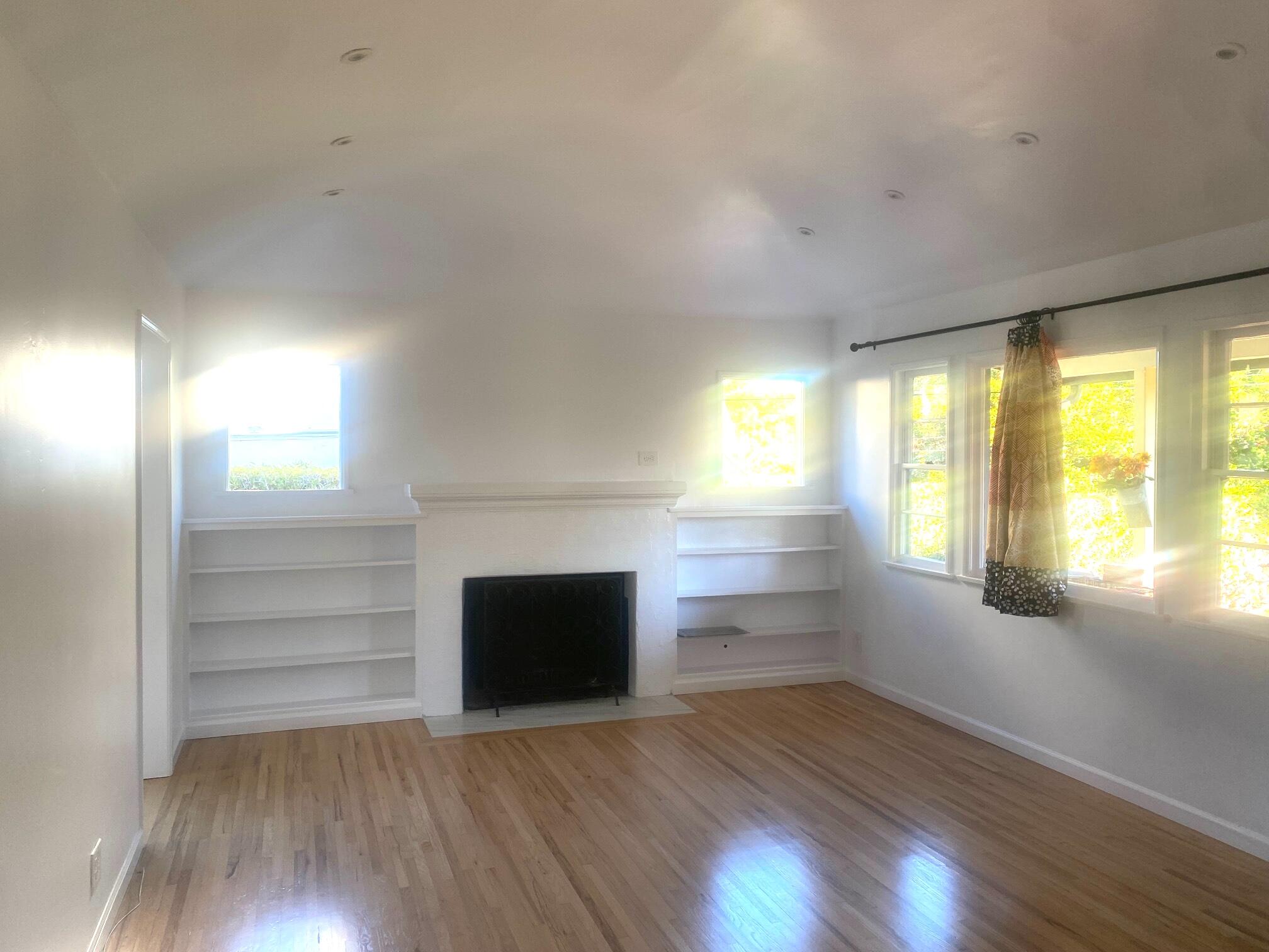 324 Arden Road Santa Barbara, CA 93105 - Photo 4 of 17 an empty room with wooden floor fireplace and windows