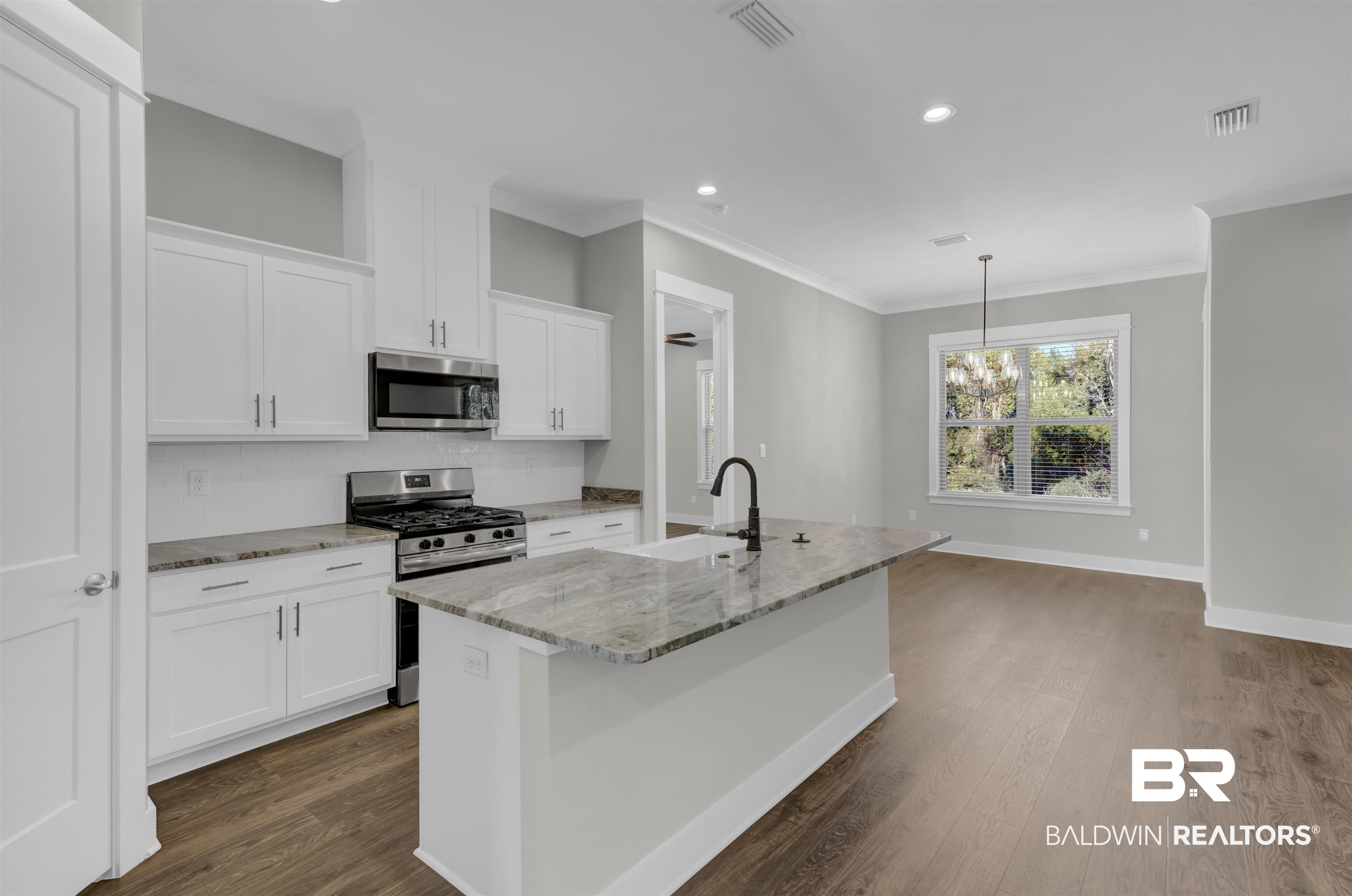 571 Morning Mist Way Fairhope, AL 36532 - Photo 6 of 47 Kitchen featuring light stone counters, appliances with stainless steel finishes, a kitchen island with sink, white cabinets, and recessed lighting