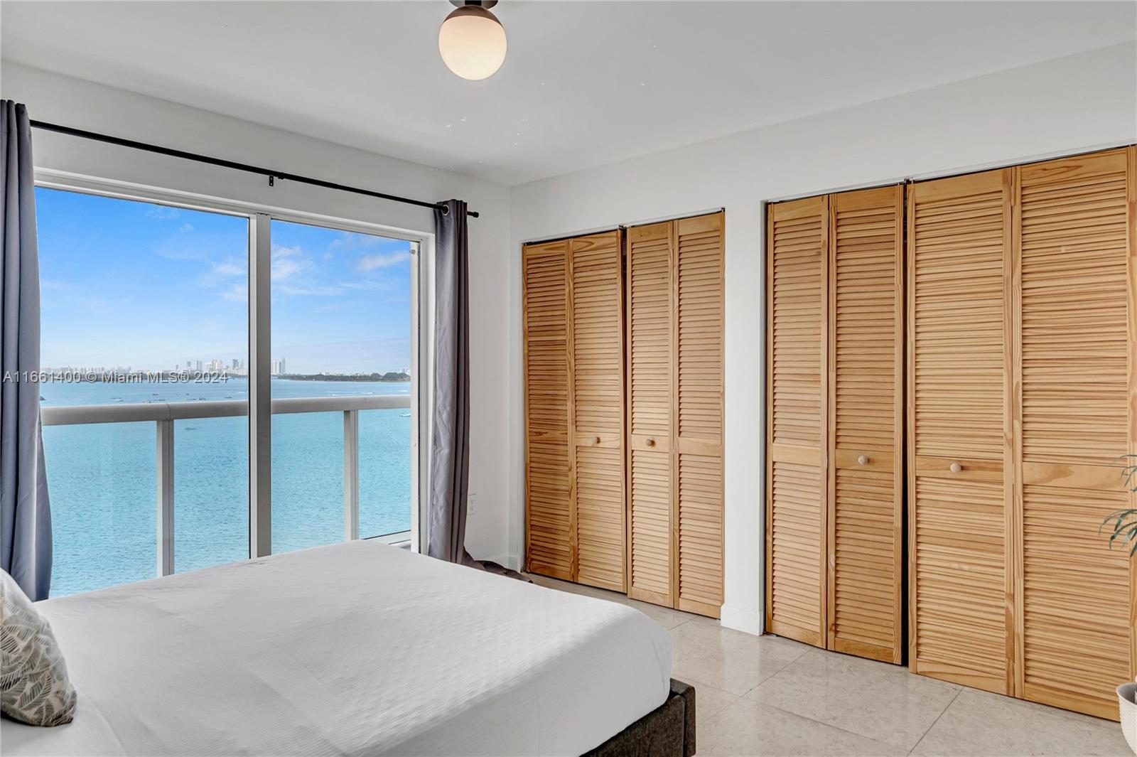 7939 East Drive, Unit 13 North Bay Village, FL 33141 - Photo 17 of 31 a bedroom with a bed and a large window