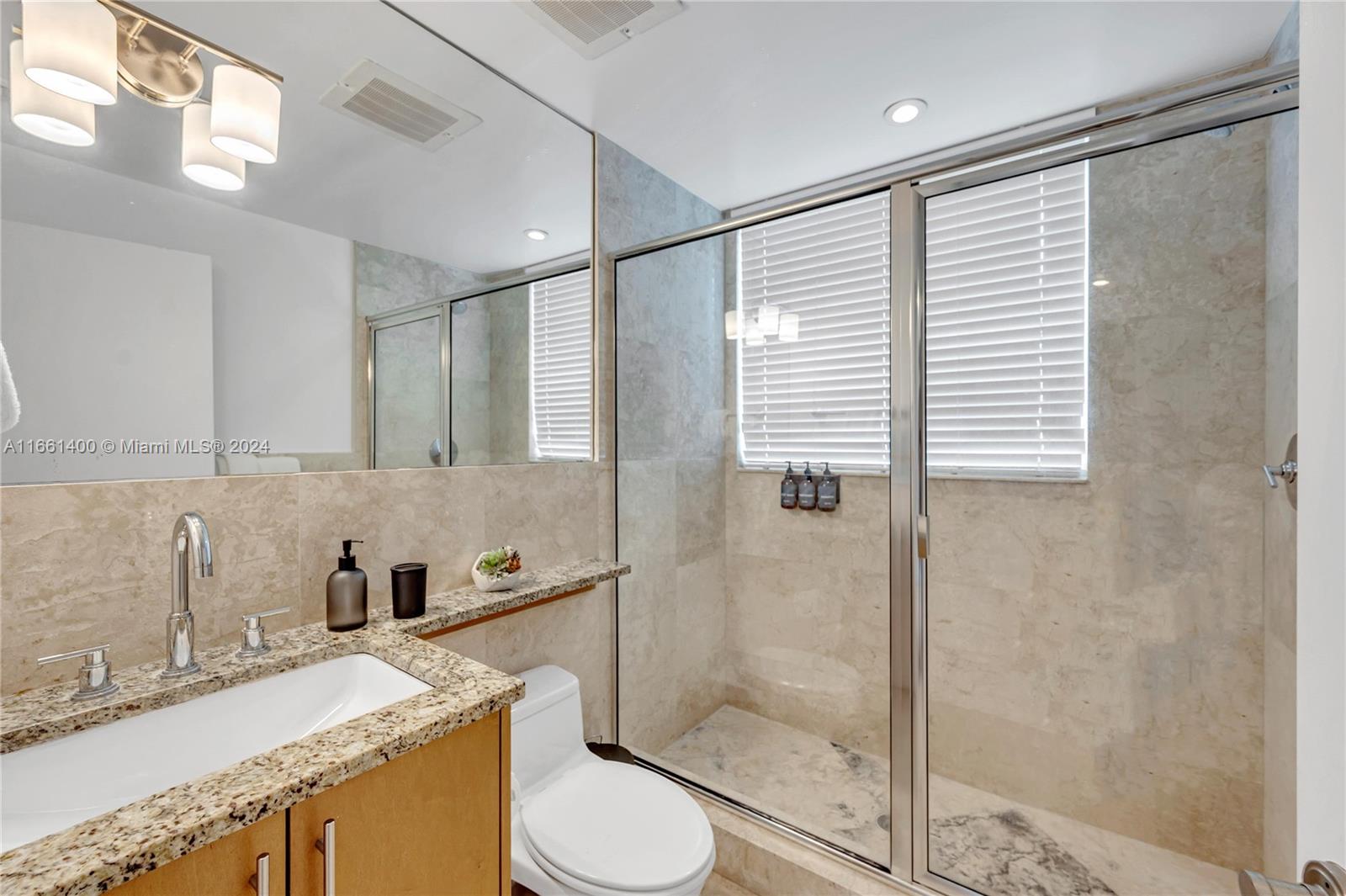 7939 East Drive, Unit 13 North Bay Village, FL 33141 - Photo 30 of 31 a bathroom with a granite countertop sink toilet and shower