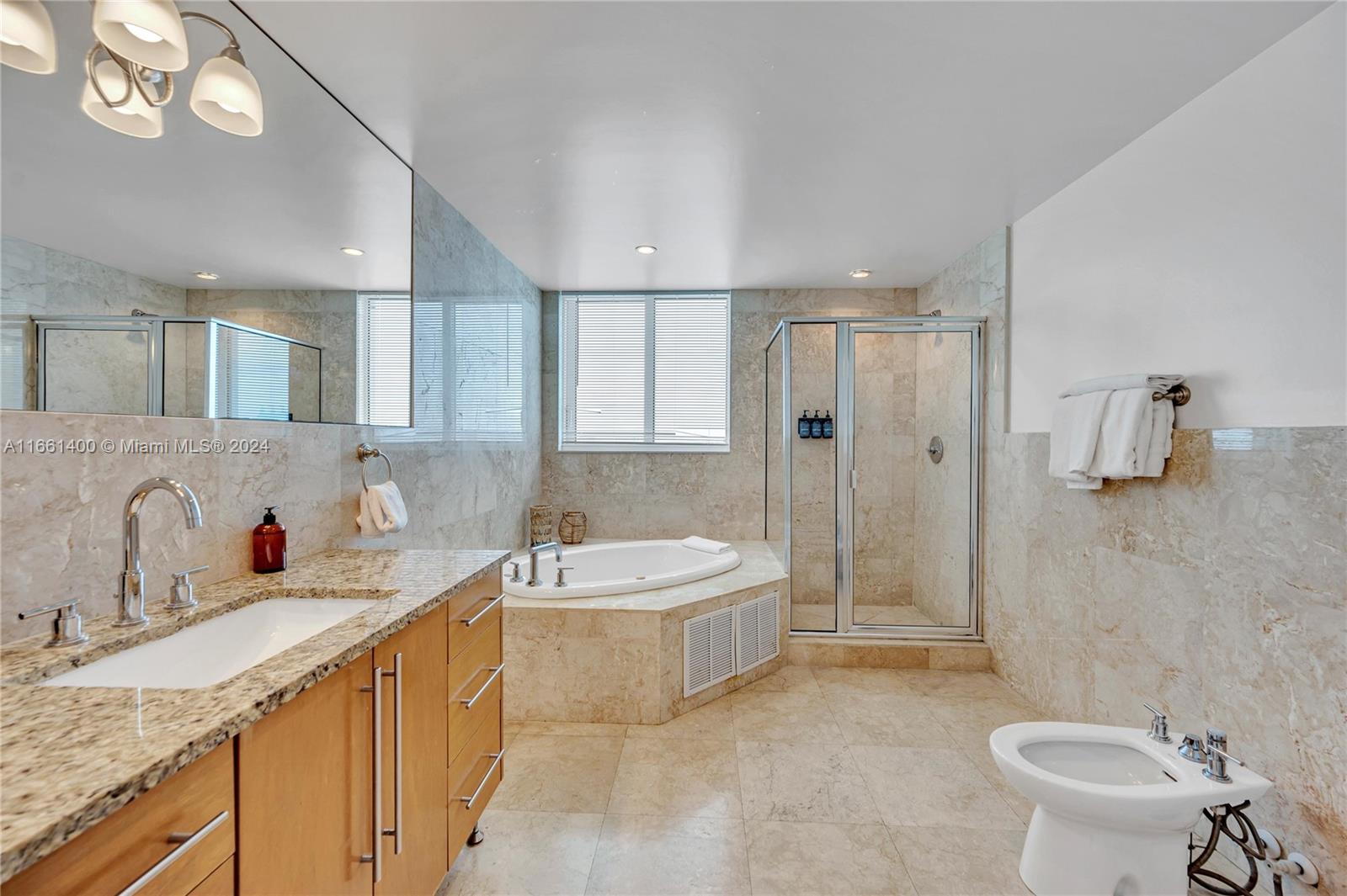 7939 East Drive, Unit 13 North Bay Village, FL 33141 - Photo 9 of 31 a bathroom with a granite countertop sink mirror and toilet
