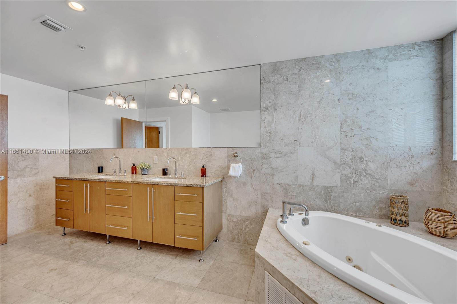 7939 East Drive, Unit 13 North Bay Village, FL 33141 - Photo 10 of 31 a bathroom with a bathtub a mirror a sink and vanity
