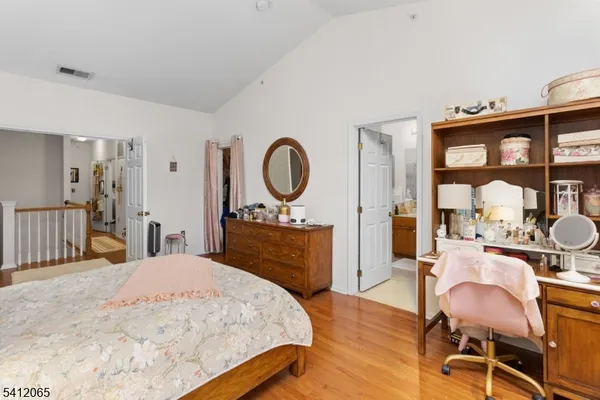 a bedroom with a bed and dresser with mirror