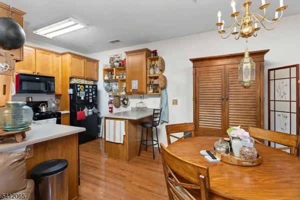 a room with stainless steel appliances kitchen island granite countertop furniture and a wooden floor